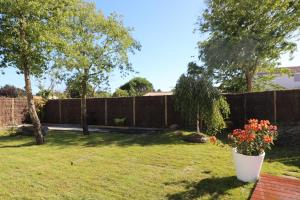 ein Garten mit Zaun und einer Vase mit Blumen in der Unterkunft Magnifique villa Piscine Spa Billard in L'Ile d'Yeu