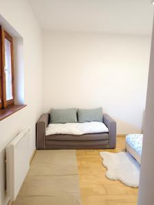 a living room with a couch in the corner of a room at Maisonnette proche de Strasbourg in Vendenheim