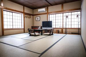 a living room with a table and a tv at Guest house SENWA in Yuzawa