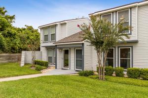 a house with a green lawn in front of it at Pet Friendly Beach Retreat - Fernandina Shores - 6355 in Fernandina Beach