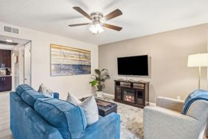 a living room with a blue couch and a tv at Pet Friendly Beach Retreat - Fernandina Shores - 6355 in Fernandina Beach