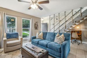 a living room with a blue couch and a staircase at Pet Friendly Beach Retreat - Fernandina Shores - 6355 in Fernandina Beach +46 photos