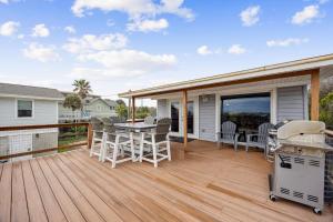 a deck with a table and chairs and a grill at Spacious Beachfront Duplex - Top Floor - Dog Friendly - 124 S Fletcher in Fernandina Beach