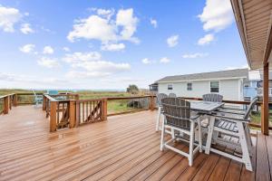 a wooden deck with a table and chairs on it at Spacious Beachfront Duplex - Top Floor - Dog Friendly - 124 S Fletcher in Fernandina Beach