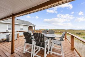 a patio with a table and chairs on a deck at Spacious Beachfront Duplex - Top Floor - Dog Friendly - 124 S Fletcher in Fernandina Beach