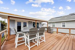 a wooden deck with a table and chairs on it at Spacious Beachfront Duplex - Top Floor - Dog Friendly - 124 S Fletcher in Fernandina Beach