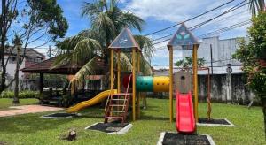 a playground with a slide in a yard at Hotel De Cassia in Kampar