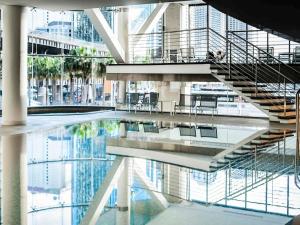 un edificio con una piscina d'acqua con scale e sedie di Pullman Quay Grand Sydney Harbour a Sydney