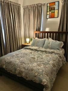 1 dormitorio con 1 cama grande y cortinas en Home in Airport Residential- 2 mins from airport, en Accra