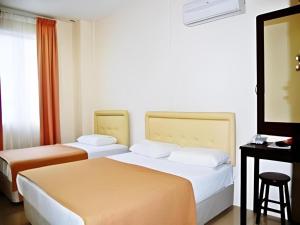 a hotel room with two beds and a flat screen tv at Rafayeh Hotel in Kampong Lobok