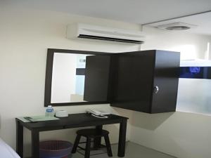 a desk with a mirror and a stool in a room at Rafayeh Hotel in Kampong Lobok
