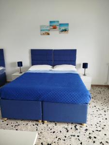 1 cama azul en un dormitorio con 2 lámparas en Sorrento Experience, en Sorrento