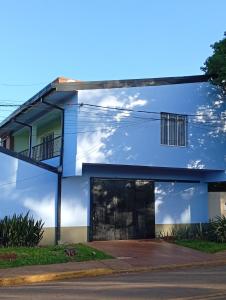 een blauw gebouw met een balkon in een straat bij Marias Alojamiento in Garupá