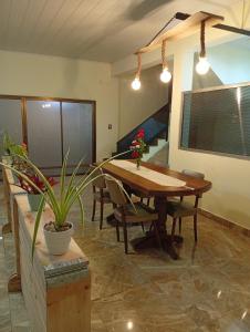 een eetkamer met een houten tafel en stoelen bij Marias Alojamiento in Garupá