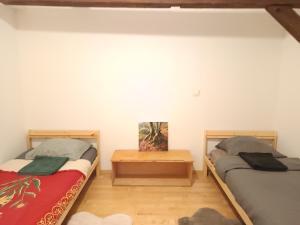 a bedroom with two beds and a wooden floor at Maisonnette proche de Strasbourg in Vendenheim