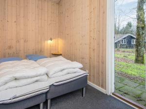 a bedroom with a bed in a wooden wall at 4 star holiday home in Ansager in Ansager