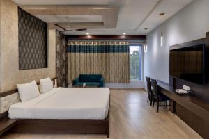 a bedroom with a bed and a desk and a television at Hotel Goodwill in Kaithal