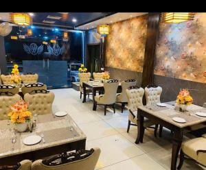 a restaurant with tables and chairs and a wall mural at Hotel Goodwill in Kaithal