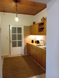 a kitchen with wooden cabinets and a sink and a door at Golden Hearth Mountain Chalet in Ano Trikala