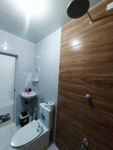 une salle de bain avec toilettes et porte en bois dans l'établissement JLG Transient Home Pagsanjan Laguna, à Pagsanjan