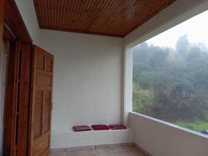 a room with a large window with two red cushions at Golden Hearth Mountain Chalet in Ano Trikala