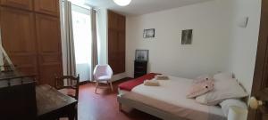 Gite - Domaine Les Peupliers - Lagnes في Lagnes: غرفة نوم بها سرير وكرسي ونافذة