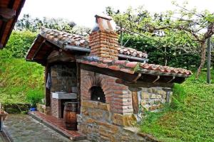 an outdoor brick oven in a yard with a grass at Albergue Rural Montebaserria in Ziortza-Bolibar