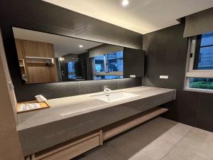 ein Badezimmer mit Waschbecken und großem Spiegel in der Unterkunft 台南圈旅 in Tainan + 75 Fotos