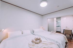 Dos camas en una habitación blanca con toallas. en Fukuoka Hakata Stay 1BR with Balcony, TV and Laundry 206, en Wada