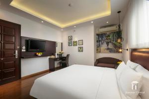 a bedroom with a white bed and a television at Hanoian Central Hotel & Spa in Hanoi