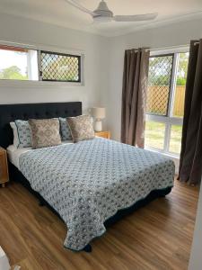 a bedroom with a large bed in a room with windows at Coastal Escape in North Coast +35 photos