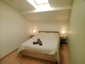 MAISON DU SOUVENIR 70 m2 près du Futuroscope في Lhommaizé: غرفة نوم بها سرير عليه صورة دب بني