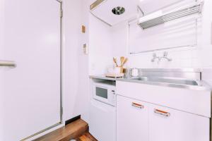 Una cocina con gabinetes blancos y un fregadero. en Fukuoka Hakata Stay 1BR with Balcony, TV and Laundry 206, en Wada
