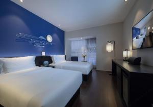 Postel nebo postele na pokoji v ubytování Orange Hotel Chengdu Huanhuaxi