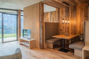 een kamer met houten wanden, een bureau en een televisie bij Berggut Niggler - Pratum in Dobbiaco