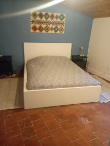 ein weißes Bett in einem Zimmer mit zwei Tischen in der Unterkunft Maison atypique centre historique in Auch