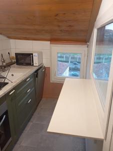 eine kleine Küche mit Theke und Mikrowelle in der Unterkunft Maison atypique centre historique in Auch