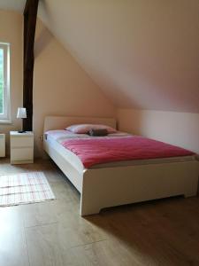 a bedroom with a bed with a red blanket at Apartment Belaj in Celje