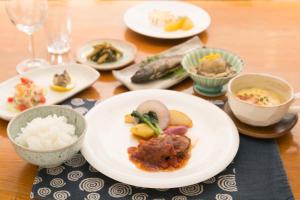 a table with plates of food and bowls of food at Ryokan Mokuzin in Hakuba
