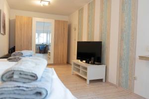 Schlafzimmer mit einem Flachbild-TV und einem Bett in der Unterkunft Seebrise Apartments in Grömitz