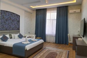 a bedroom with a bed with two swans on it at Vatan Hotel in Dushanbe