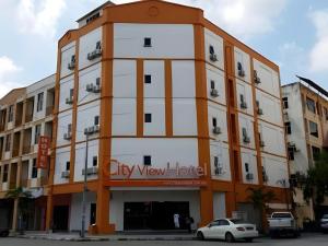 City View Hotel At KLIA & KLIA2 في Kampong Bekoh: مبنى ابيض و برتقالي مع وضع علامة عليه