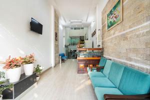 a room with a blue couch and a brick wall at Đình Đinh Hotel in Ho Chi Minh City