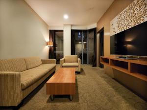 a living room with a couch and a tv at Izumi Hotel Bukit Bintang Kuala Lumpur in Kuala Lumpur