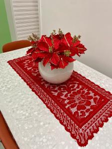 a table with a vase with red flowers on it at Seventeen Home in Naples