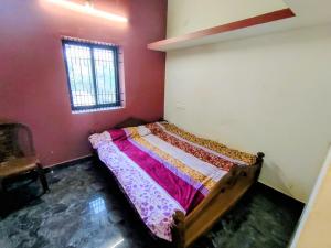 ein kleines Bett in einem Zimmer mit Fenster in der Unterkunft Farm House Shetgeri in Ankola + 2 Fotos