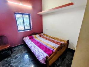 ein Schlafzimmer mit einem Bett in einem Zimmer mit Fenster in der Unterkunft Farm House Shetgeri in Ankola