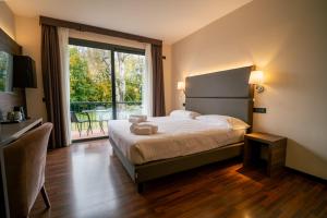 una habitación de hotel con una cama y un balcón en Yachting Hotel Mistral, en Sirmione