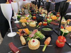 a long table filled with different types of food at Hôtel Des Vosges in La Celle-sous-Gouzon +11 photos