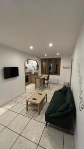 ジニャックにあるBel appartement rénové en cœur de villeの緑のソファとテーブルのあるリビングルーム